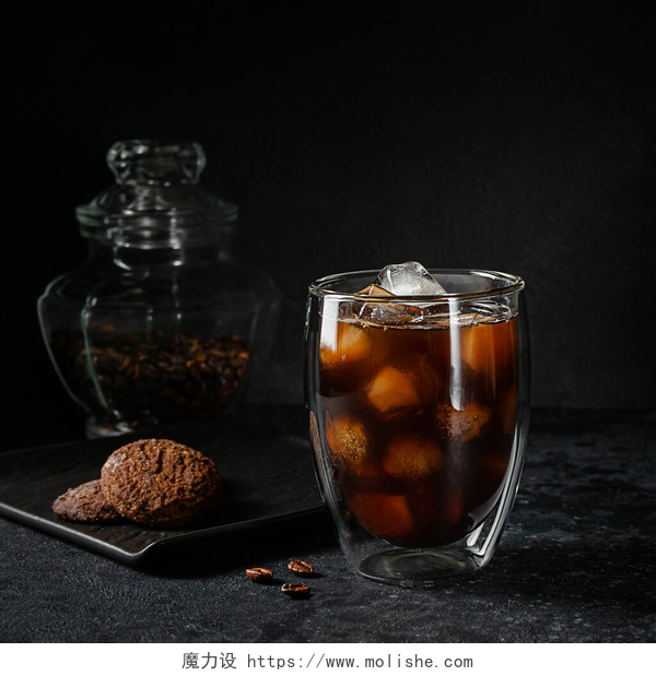 黑色桌子上的冰美式咖啡一杯美式咖啡，在深色石头的背景上装上冰块。夏日清爽饮料.